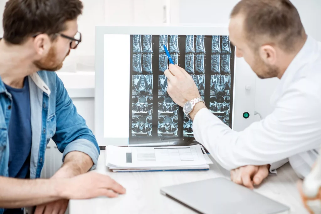 Doctor examining spinal X-Rays with his patient