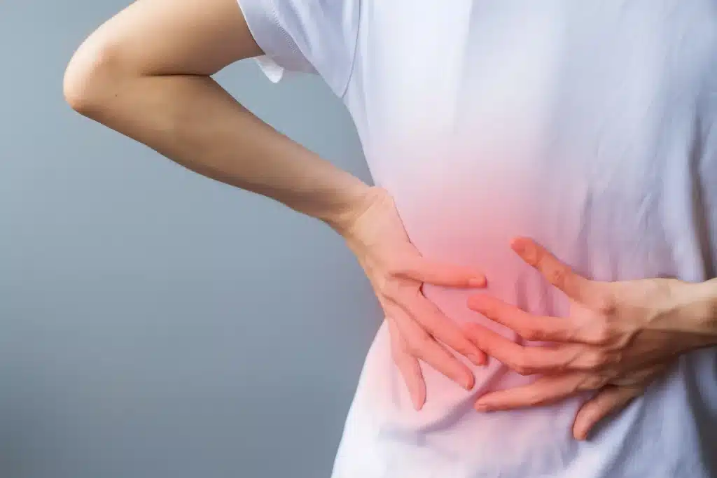 Woman in back pain because of Sacroiliac Join Pain