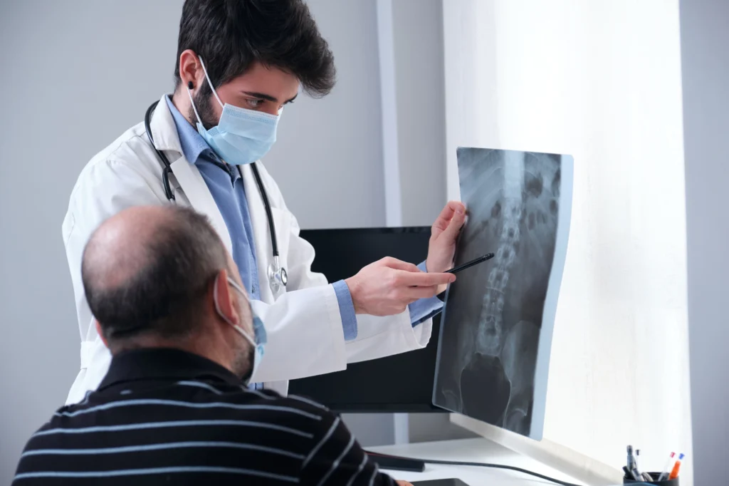 Doctor pointing to a section of the spine in an X-ray.
