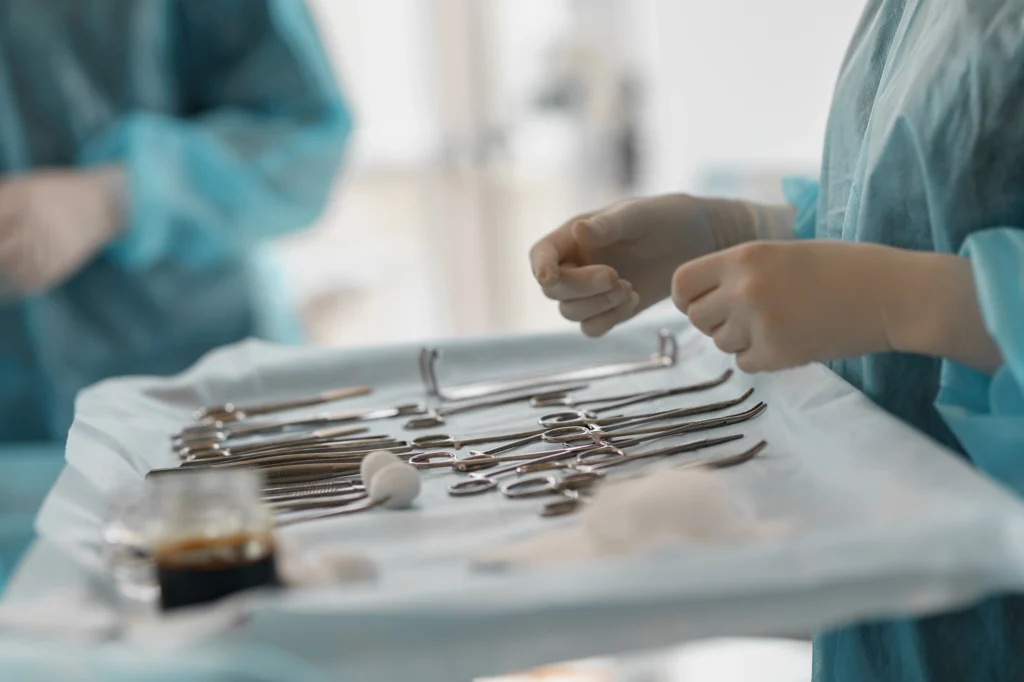 Doctors hands hovering over tools for a surgical operation