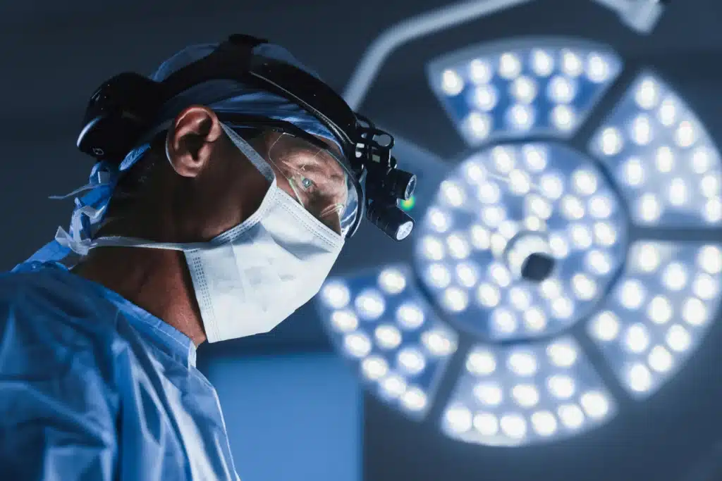 Surgeon looking down while performing surgery