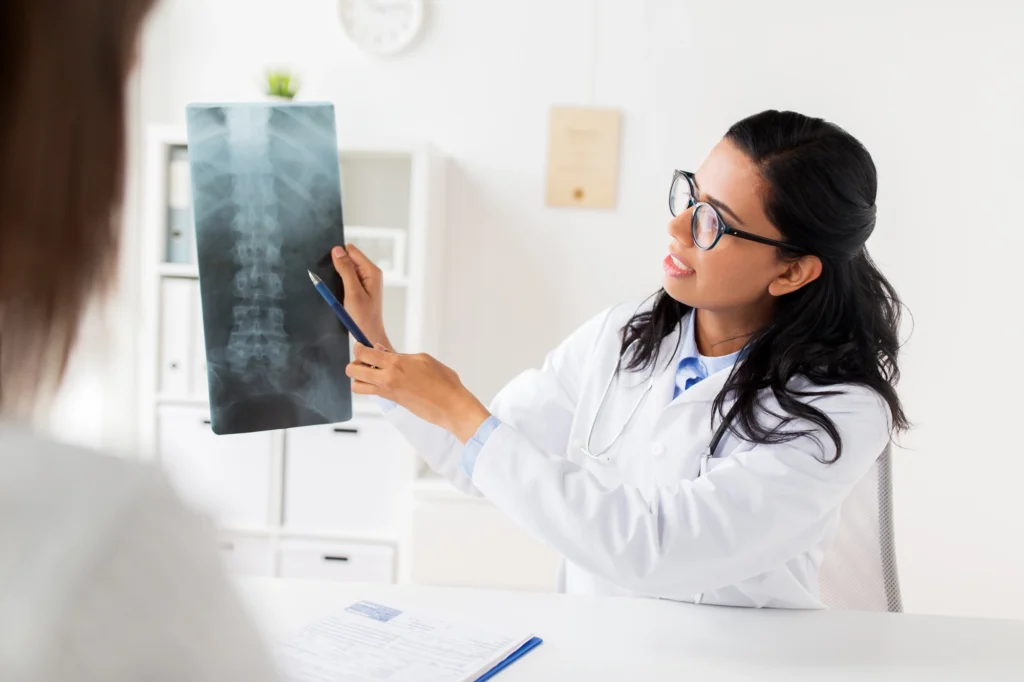 A doctor showing a patient an x-ray image of her spine