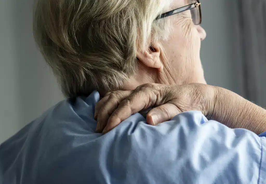 Elderly woman holding her back in pain