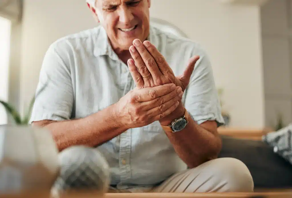 Senior man holding his hand and wrist with pain