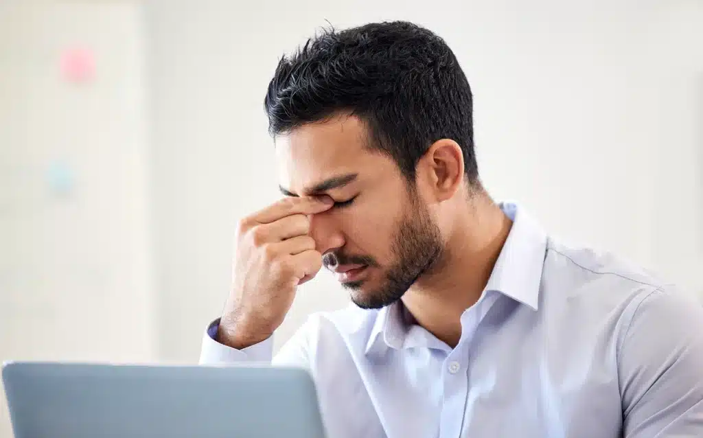 Stressed man holding his front head with pain