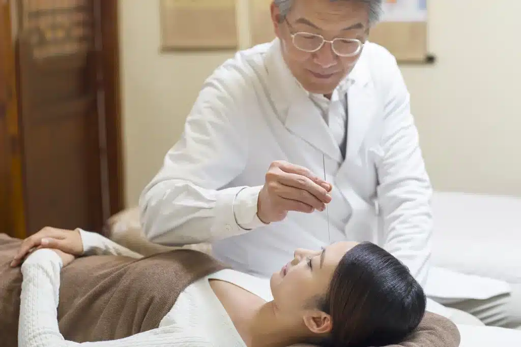 Young woman receiving acupuncture