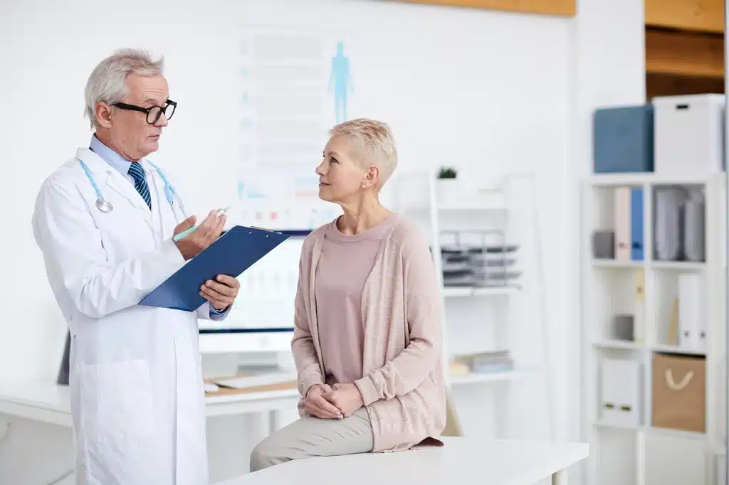 Senior doctor talking with female patient
