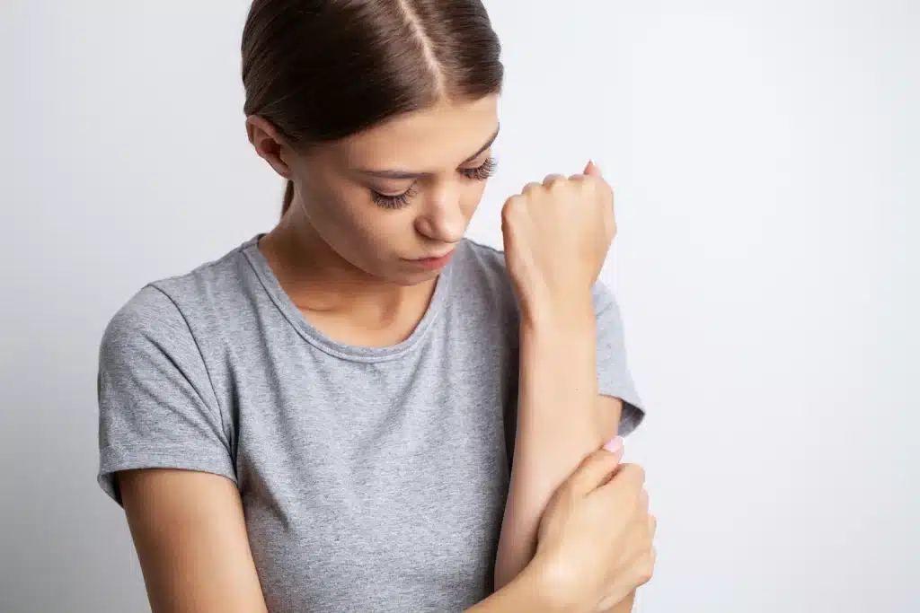 Young woman feeling pain in her arm
