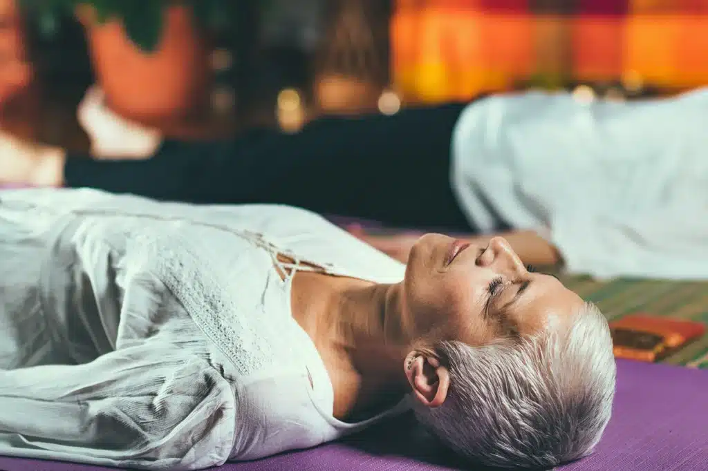 Senior woman lying on the floor in a state of meditation
