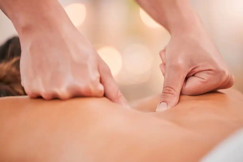 Therapist hands treating back pain with massage