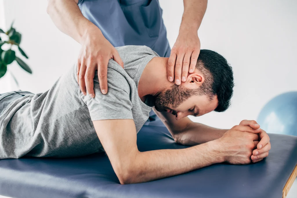 Chiropractor treating a young man with neck pain