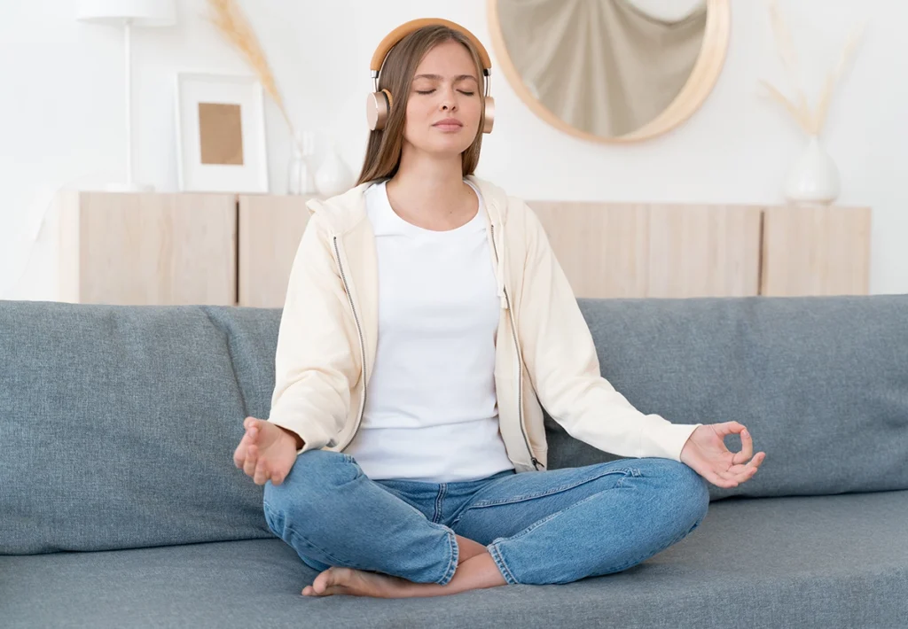 Young woman sitting on a sofa practicing mindfulness