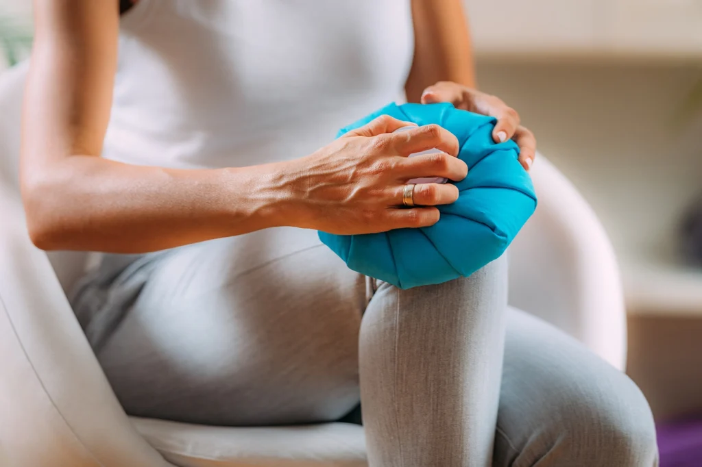 Woman applying cold therapy on her knee
