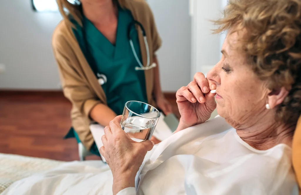 Elderly woman taking a pill after her surgery