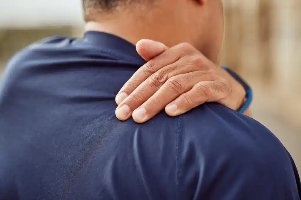Man holding his upper back in pain