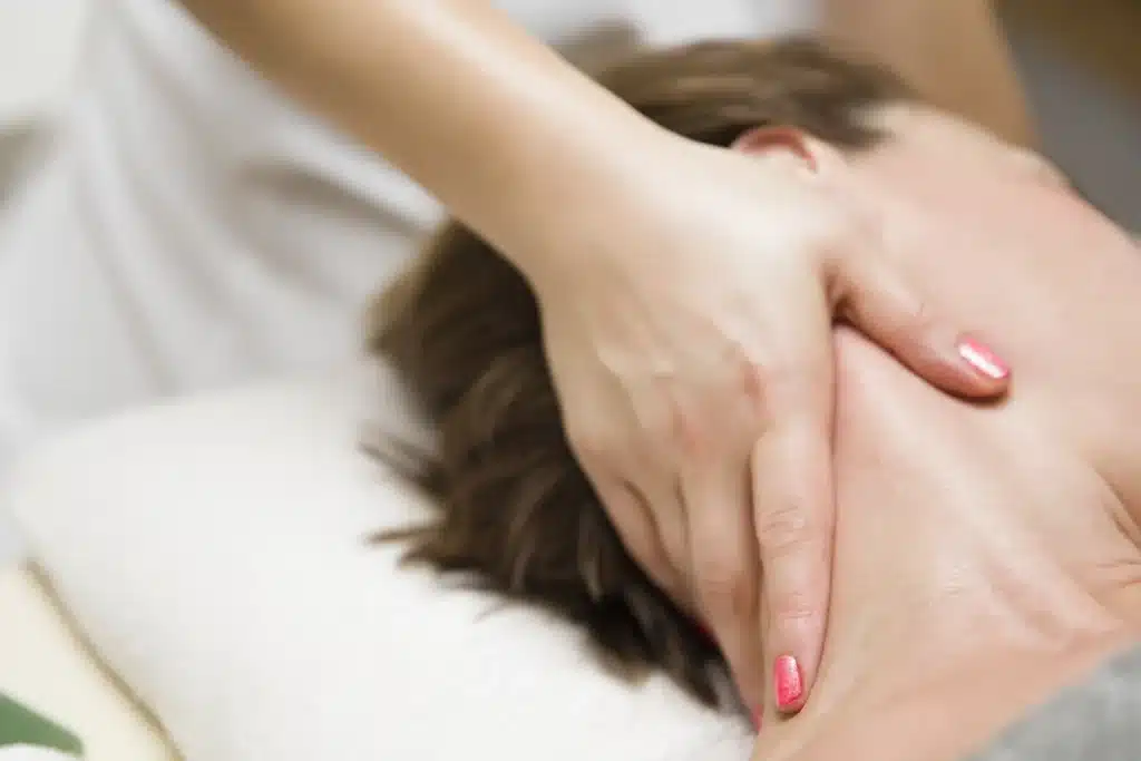 Massage therapist treating a patient's neck with pain relief massages