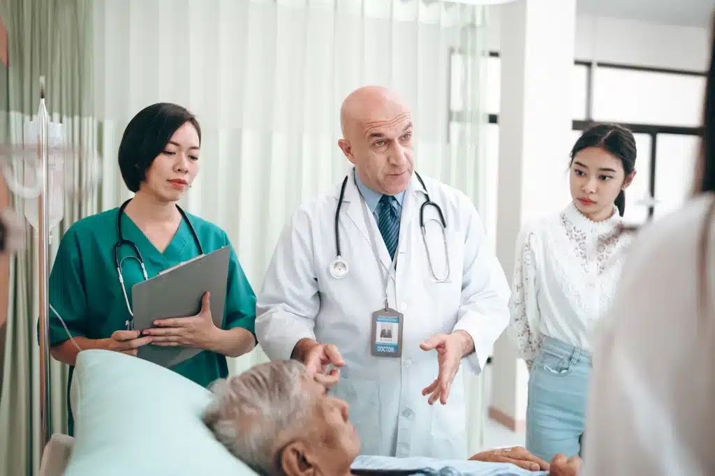 Medical professionals standing by a patient's bedside, discussing treatment plans and patient care.