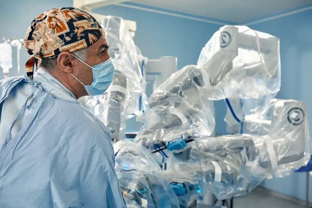 Surgeon in operating room using a minimally invasive robotic surgical system.