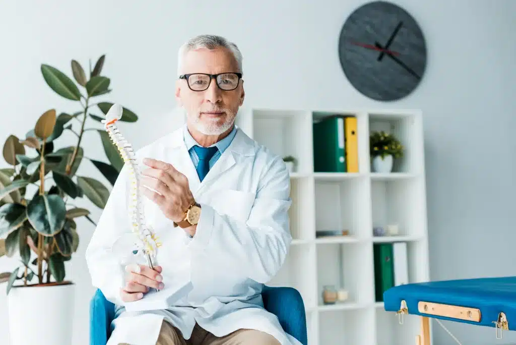 Doctor Demonstrating Spine Anatomy with Model in Office