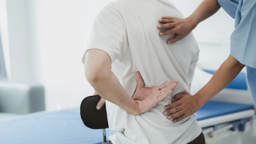 Physiotherapist assisting a patient with chronic lower back pain relief exercises.