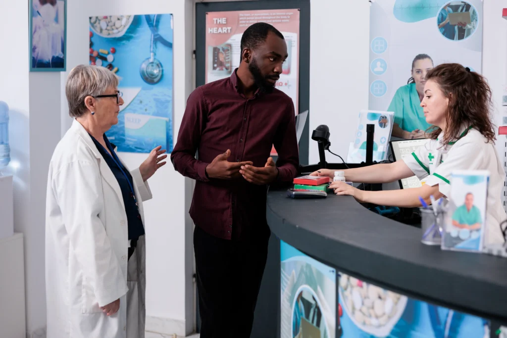 Patient discussing spinal fusion billing with pharmacy staff and doctor