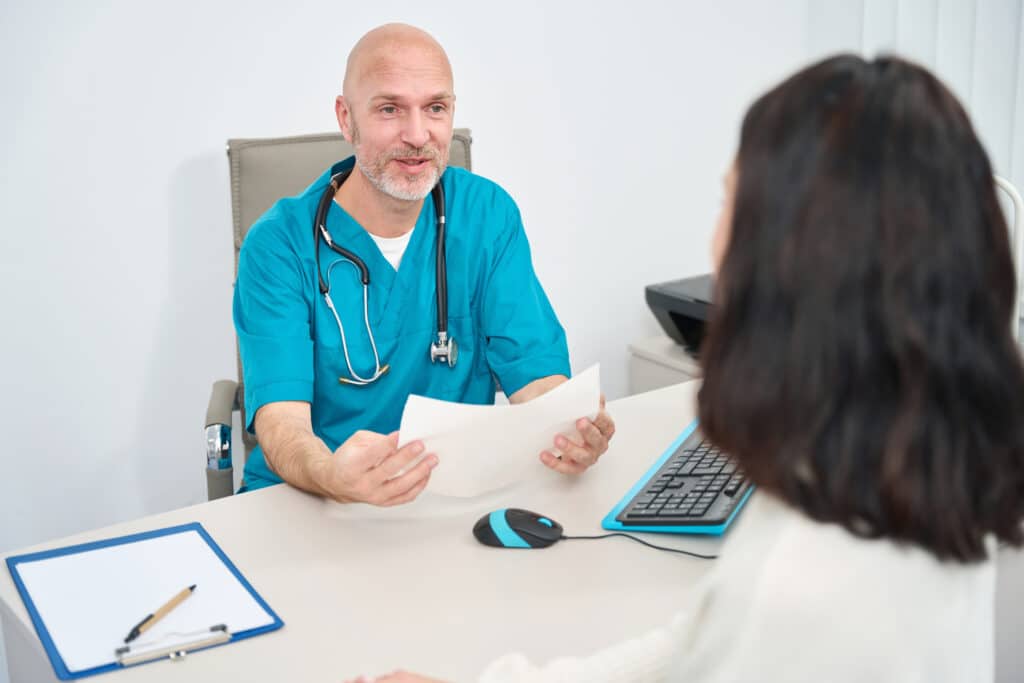 Doctor explaining recovery guidelines to a patient post spinal fusion surgery.