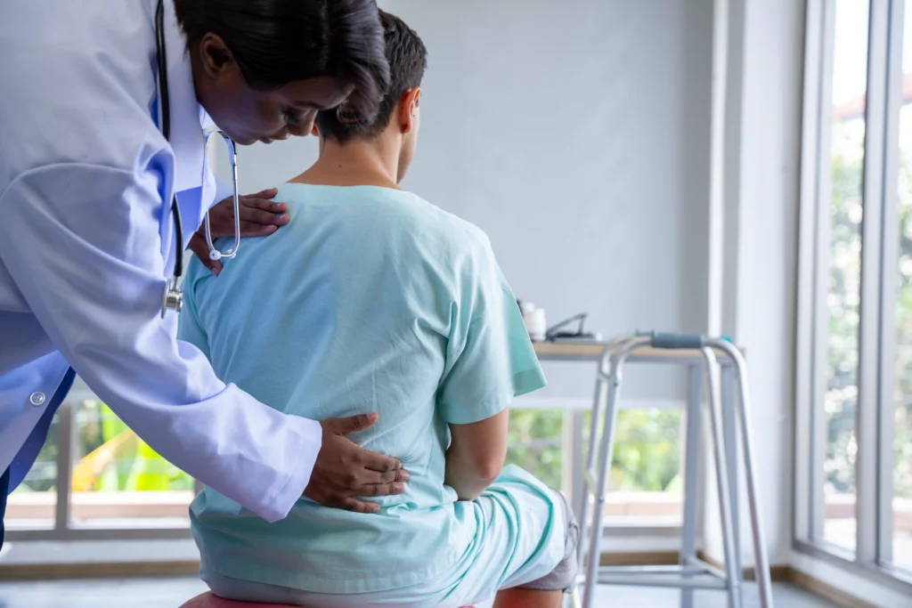 Doctor guiding a patient through exercises to relieve chronic lower back pain.