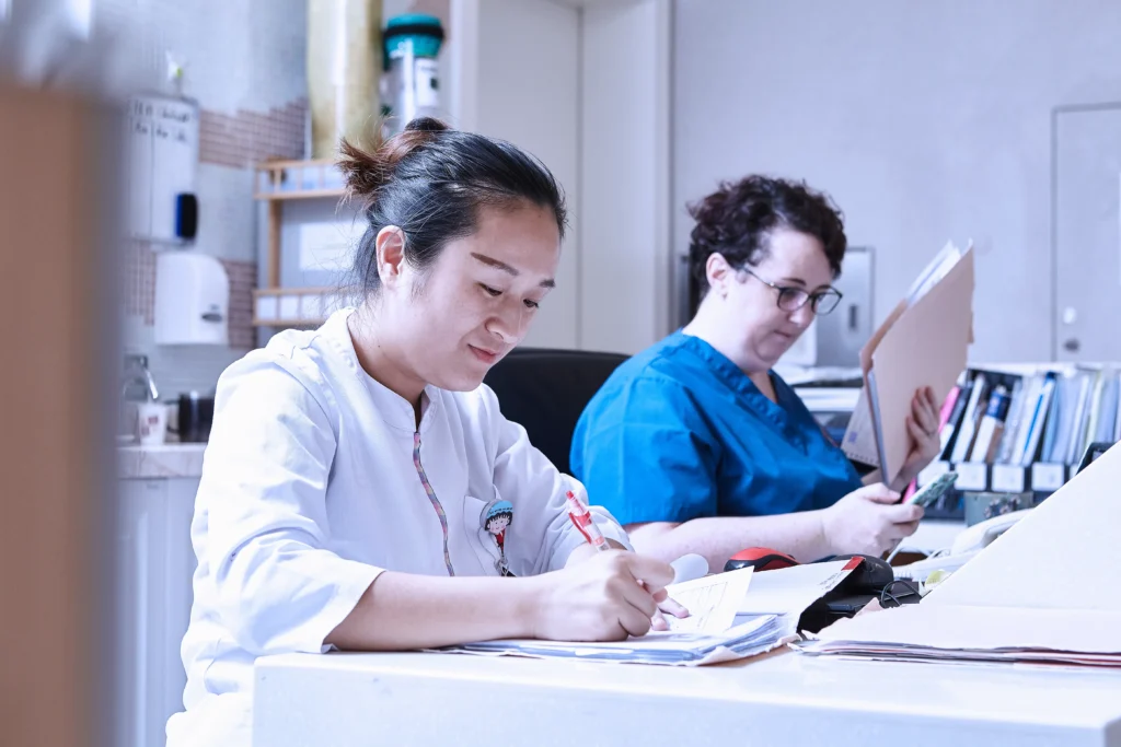 Healthcare professionals reviewing patient documents, possibly related to spinal fusion disability ratings and claims.