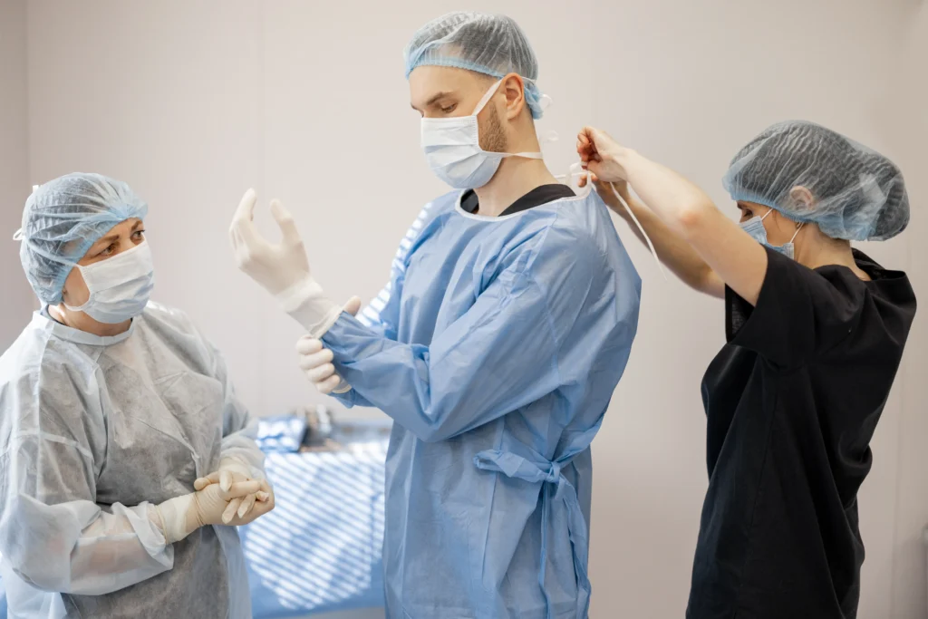 Surgeon preparing for spinal fusion surgery, focusing on sterile techniques as part of the spinal fusion protocol.