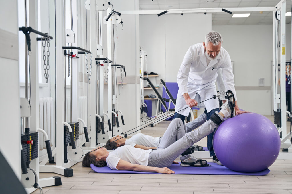 Patient undergoing strength training exercises in physical therapy after spinal fusion failure treatment.