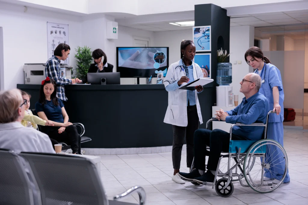 Healthcare professional assisting an elderly patient in a wheelchair, preparing for a discussion on artificial disc replacement costs and options.