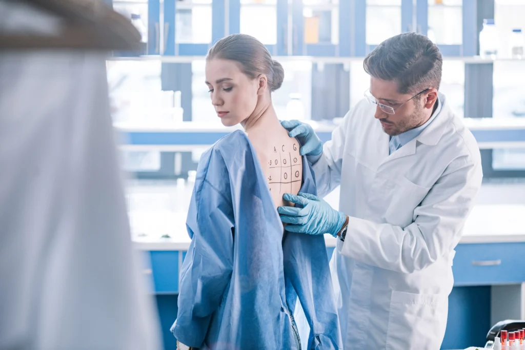 Doctor marking patient’s back during examination after spinal fusion surgery.