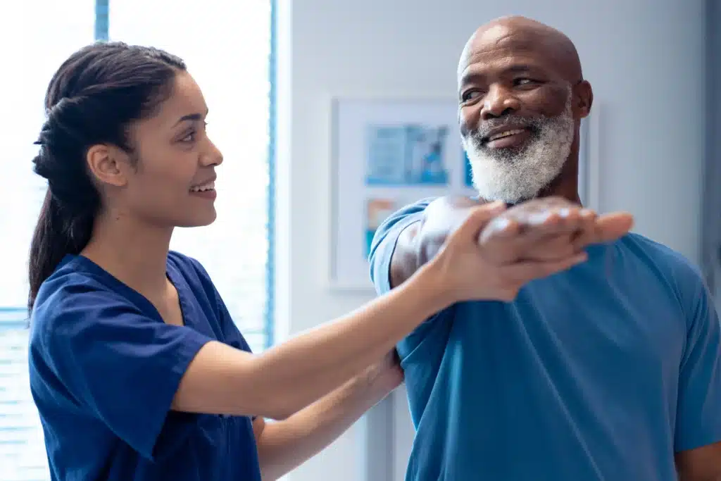 Physical therapist assisting patient with shoulder mobility exercises after spinal fusion.