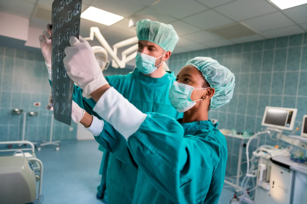 Surgeon team reviewing spinal X-rays before spinal fusion surgery.