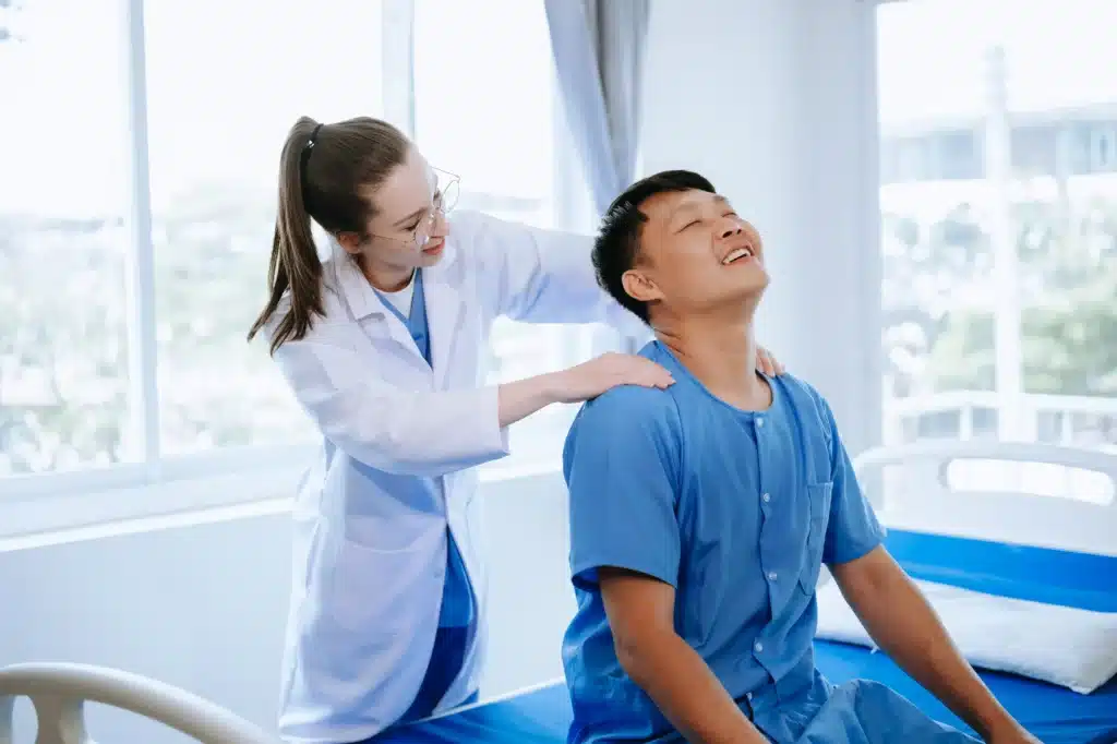 Doctor consulting with a patient experiencing back pain in a medical facility, focusing on pain management solutions in New York.