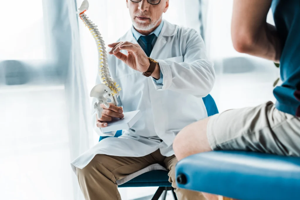 Doctor explaining back pain and its potential connection to chest pain with a spine model