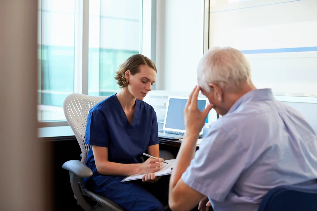 Doctor performing a pain assessment with an elderly male patient during a consultation, evaluating discomfort and treatment options.