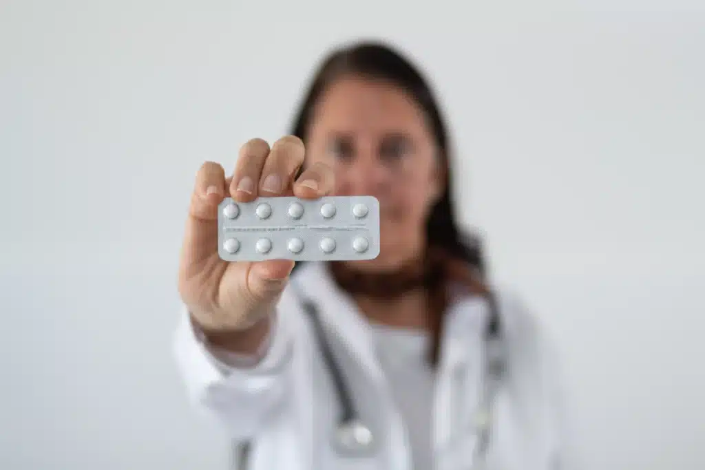 Healthcare provider displaying a blister pack of opioid pills for pain treatment.