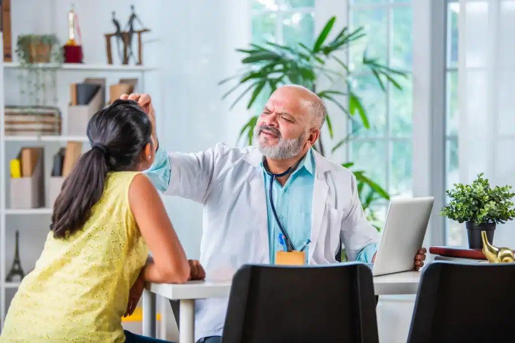 Pain management specialist on Long Island examining a young girl’s symptoms in a medical setting.