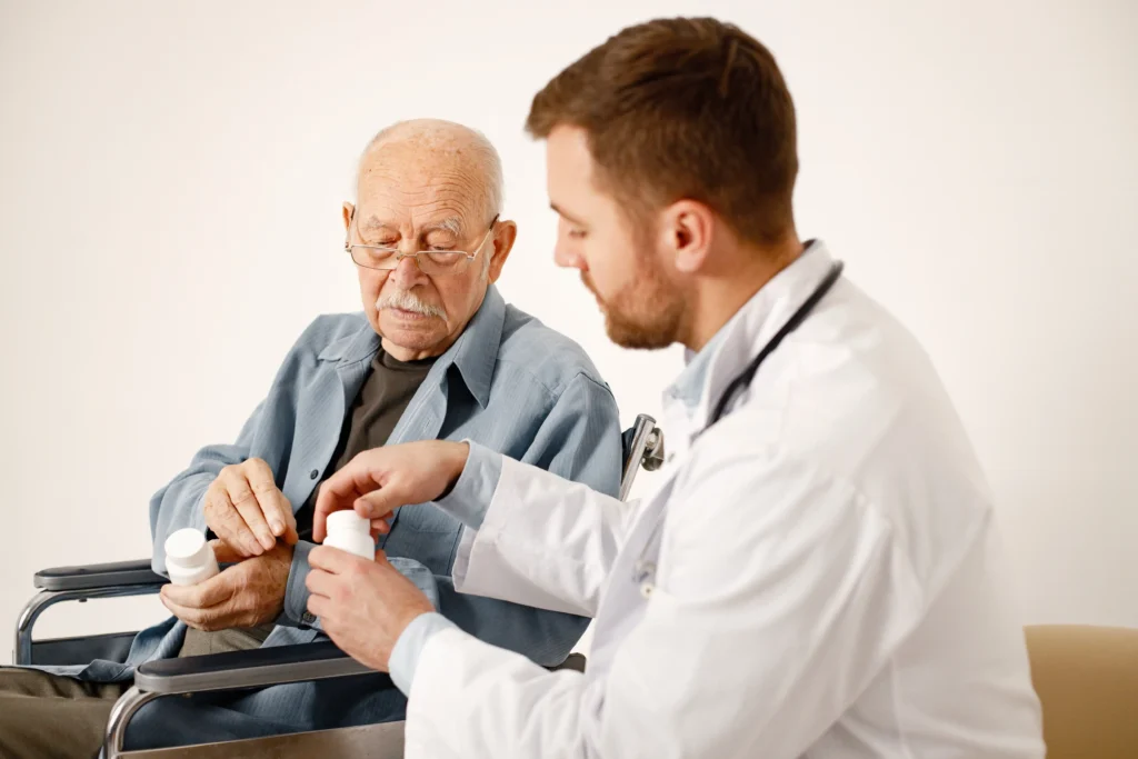 Doctor explaining medication to an older adult in a wheelchair, emphasizing safe pain management strategies for seniors.