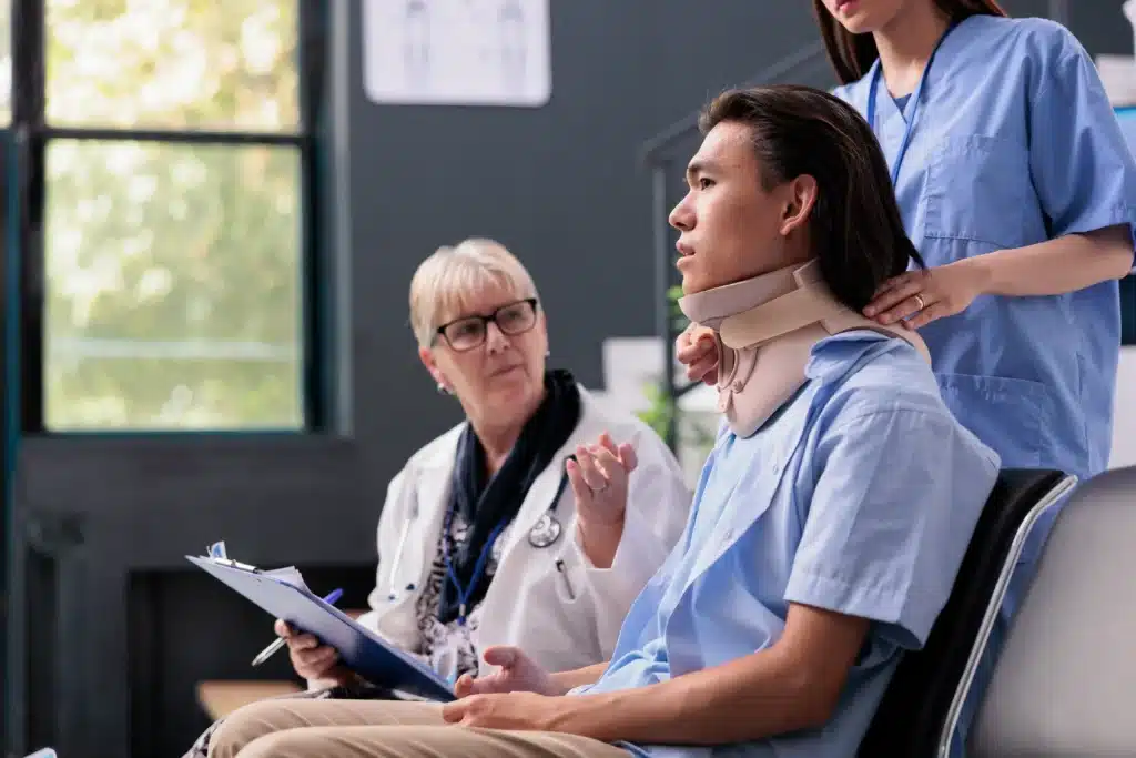 Medical team, including an orthopedist, helping a patient with a neck injury as part of a comprehensive pain management program in New York.