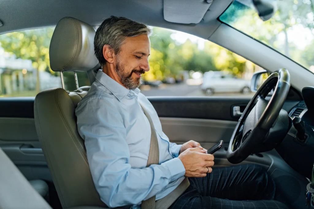 Smiling driver preparing for a long journey with ergonomic adjustments to prevent back pain from driving.