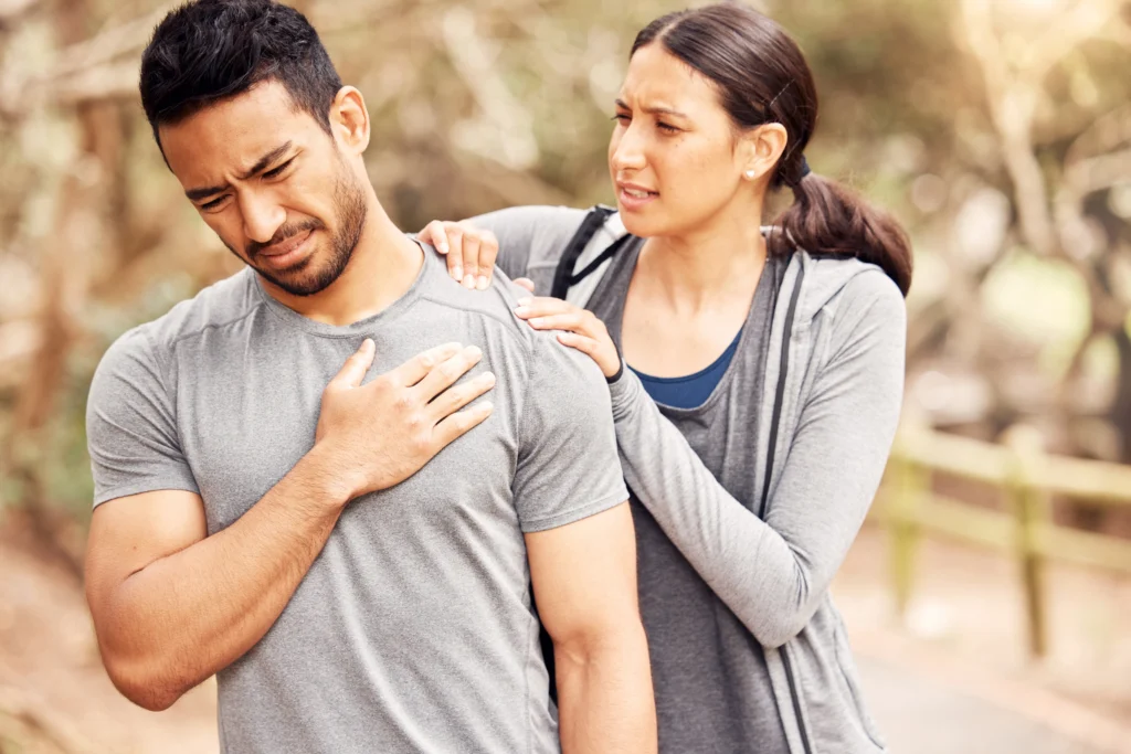 Man with chest pain while exercising, assisted by a woman, questioning the relationship with back pain