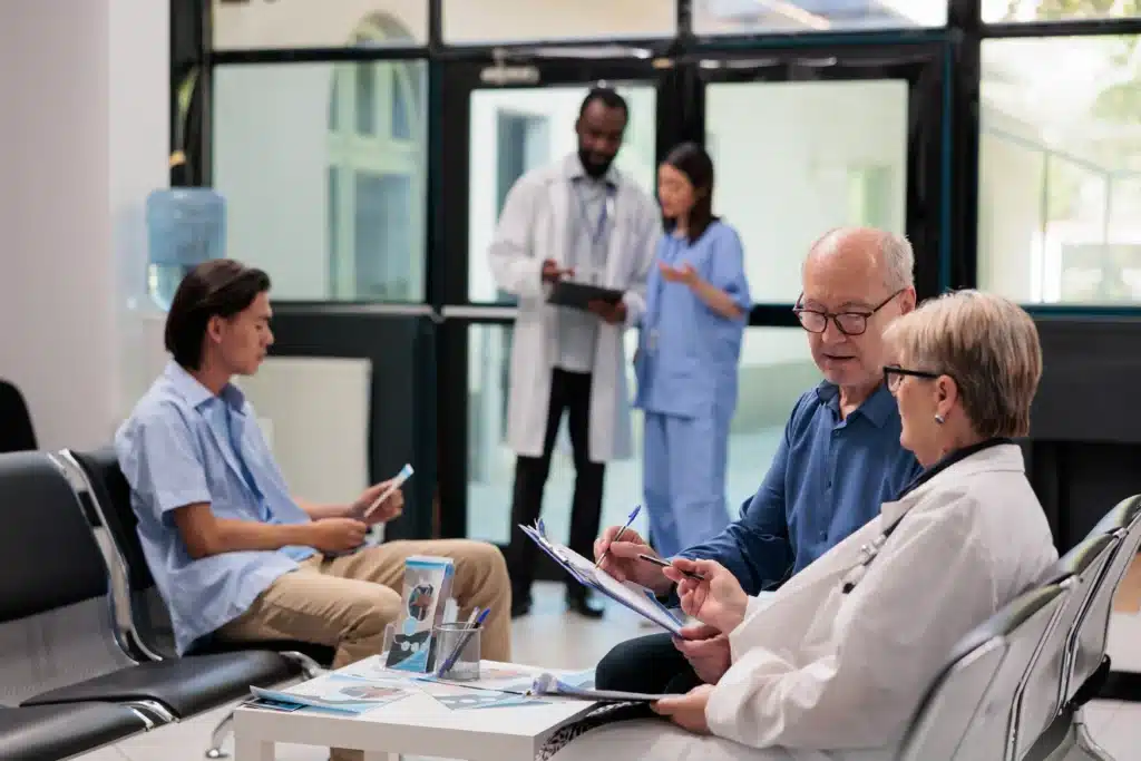 Senior medical specialist consulting with patient in Long Island hospital lobby about spine surgery procedures and costs.