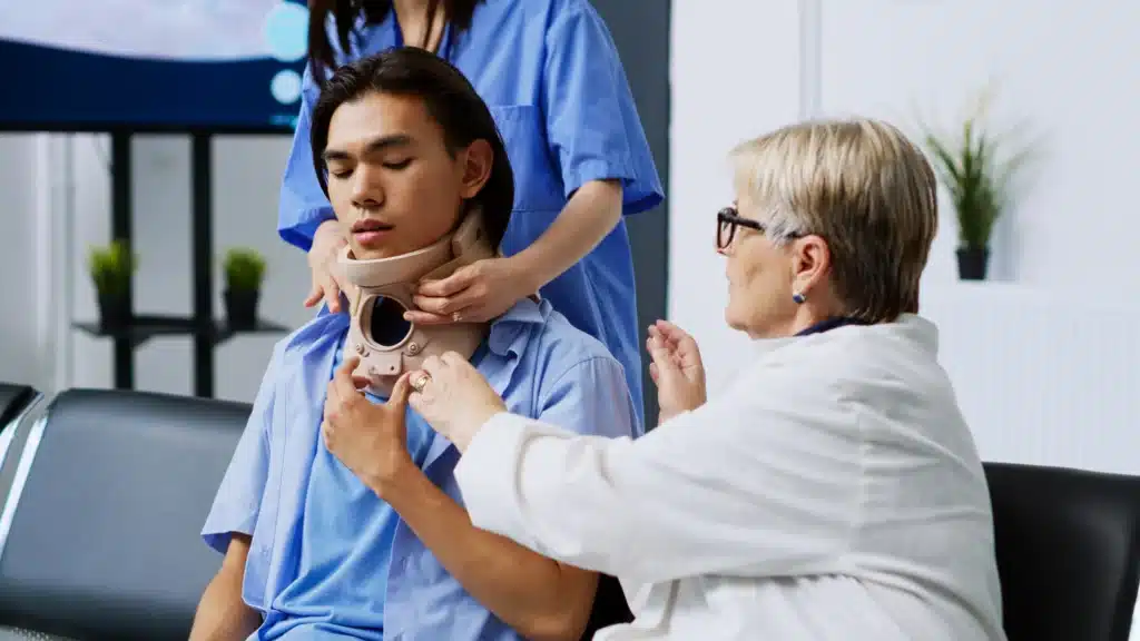 Medical professional assisting an Asian male patient with a cervical neck collar, highlighting the treatment process for cervical neck pain.