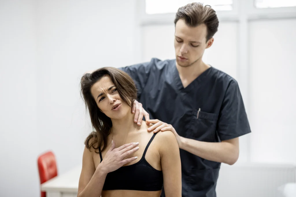 Physical therapist examining a woman’s back pain during a consultation, using clinical assessment tools to determine treatment options.