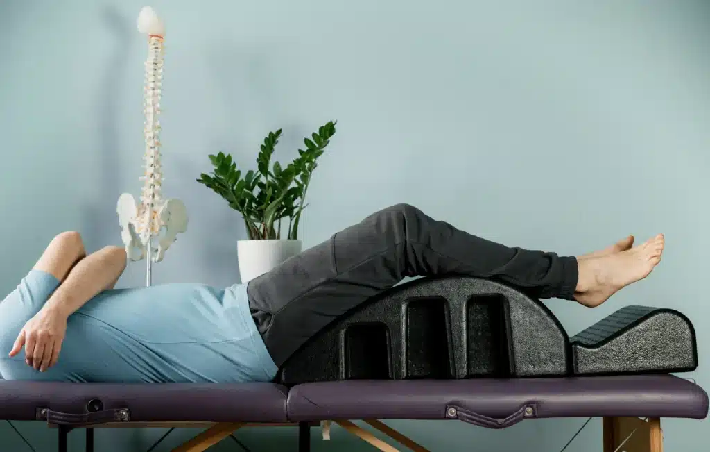 Man lying on a pilates arc for back pain relief fast, showcasing a posture correction therapy.