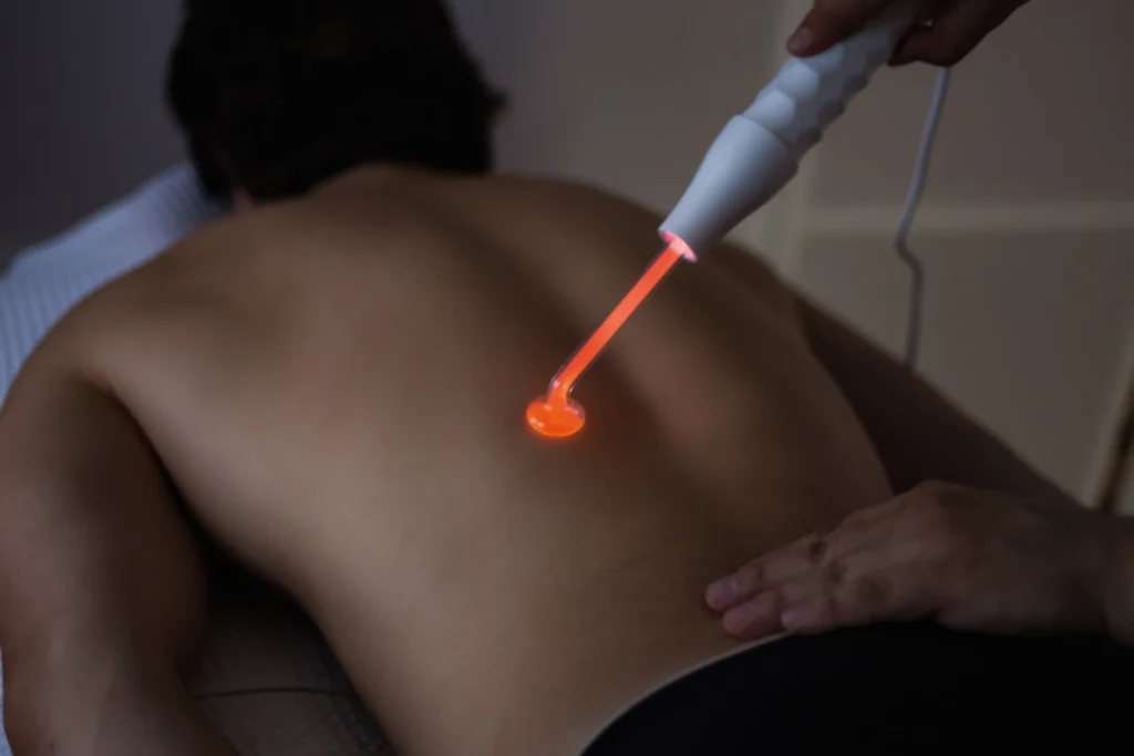 Patient receiving back pain laser treatment with non-invasive low-level laser therapy.