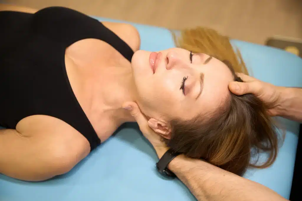 Chiropractor performing neck treatment on a woman, emphasizing therapeutic techniques like the McKenzie Method.