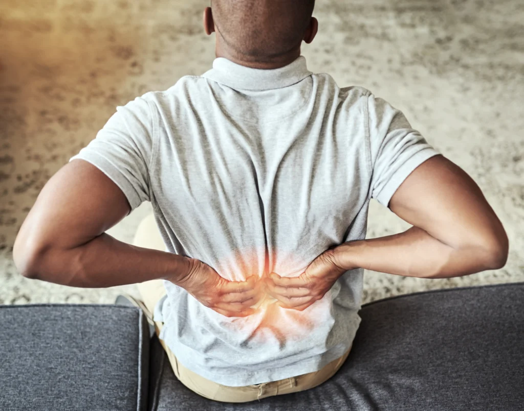 Man holding his lower back in pain with a glowing indicator, highlighting back pain symptoms in comparison to kidney stone pain.